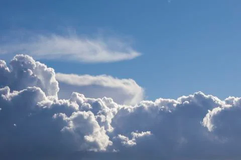 Cumulus clouds on blue sky background highlighted with sun Stock Photos