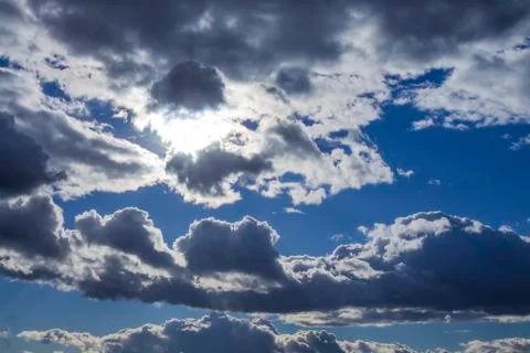 Cumulus clouds on blue sky background highlighted with sun Stock Photos
