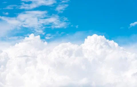 Cumulus clouds on blue sky, view from airplane window Stock Photos