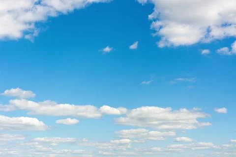 Cumulus clouds in a bright blue sky. Stock Photos