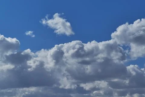 Cumulus clouds in the clear blue sky. Stock Photos