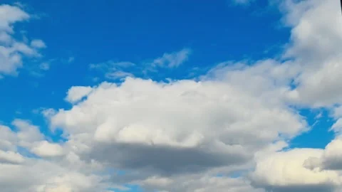 Cumulus clouds drifting across bright blue daytime sky over horizon. Timelaps Stock Footage 331592803