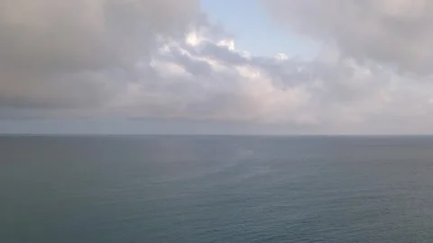 Cumulus clouds float low over the sea horizon, the seascape in gamut of shades Stock Footage 274541679