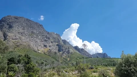 Cumulus Clouds Gathering Behind A Mountain Stock Footage 169579737