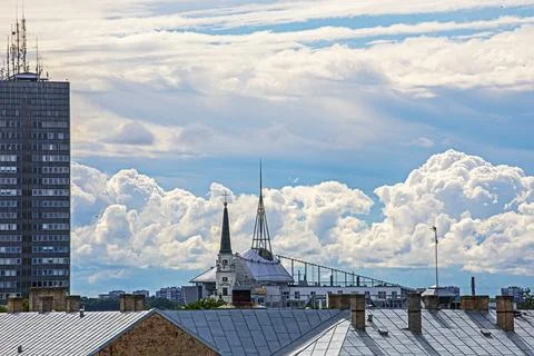 Cumulus clouds illuminated by the sun over the rooftops of the city Fotos Stock