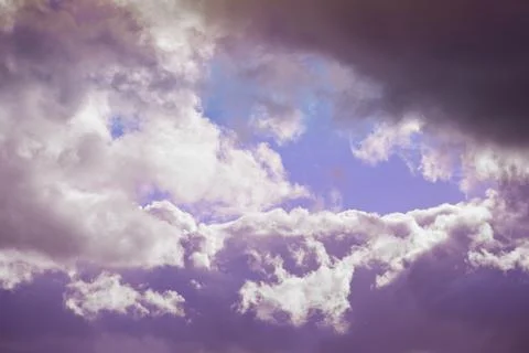 Cumulus clouds in light lilac light of the evening sun close-up view from abo Stock Photos