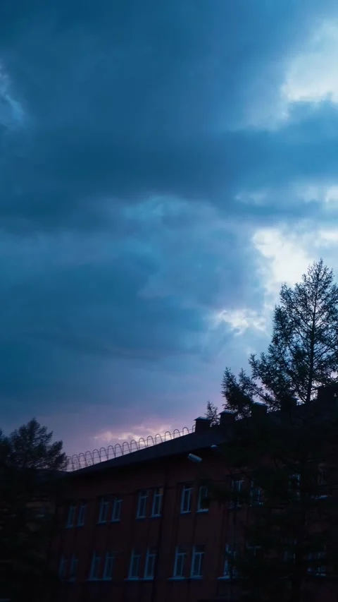 Cumulus clouds moving rapidly across sky over an old industrial brick building Stock Footage 263904337