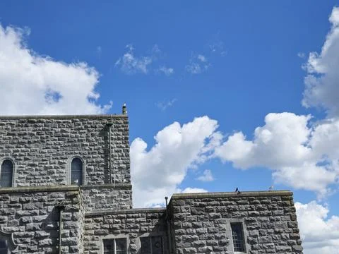 Cumulus Clouds Over a Brick Building with Windows Stock Photos
