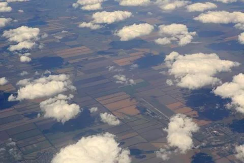 Cumulus clouds over the fields from airplane view Stock Photos