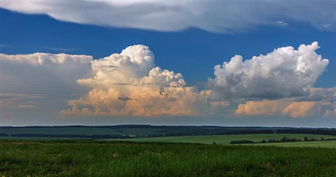 Cumulus clouds over a green field Stock Footage 293315069