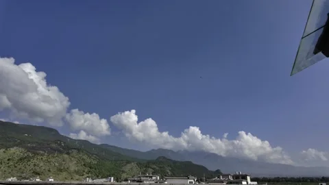 Cumulus Clouds Over Green Mountains And Buildings Under Blue Sky Stock Footage 340131598