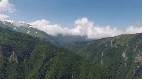 Cumulus clouds over the tops of beautiful mountains. Stock Footage 107830856