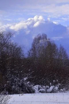 Cumulus clouds over the Ural winter forest. Frontal weather change. Stock Photos