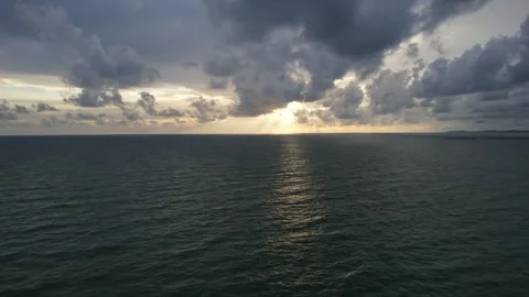 Cumulus clouds part, sun shines on ocean creating a stunning natural landscape Stock Footage 272839942