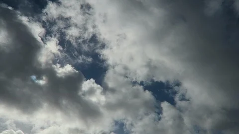 Cumulus clouds pass overhead The sun shines through Stockbeeldmateriaal 112783052