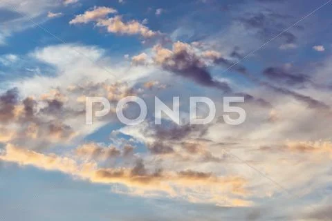 Cumulus clouds on sunset sky background Stock Photos