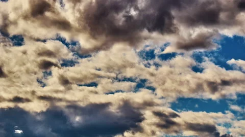 Cumulus clouds timelapse, white and dark hue moving rapidly across the blue sky Stock Footage 237077092