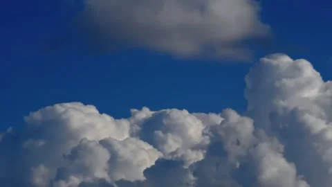 Cumulus Cloudscape: A Vivid Display of White Clouds Against a Deep Blue Sky Stock Footage 302298727