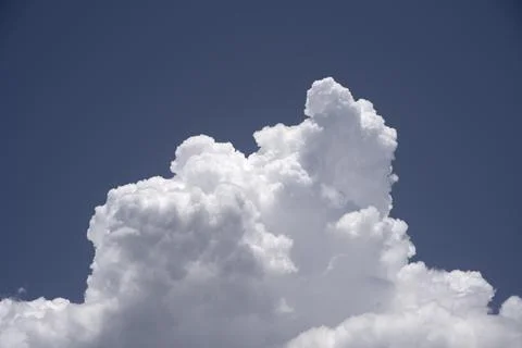 Cumulus congestus cloud. A single white clouds with sharp edges under a blue Stock Photos