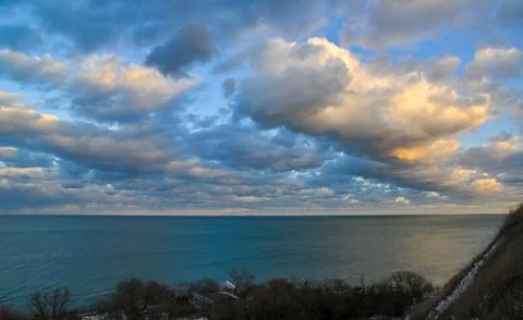 Cumulus white clouds in the evening at sunset low over the Black Sea Stock Photos