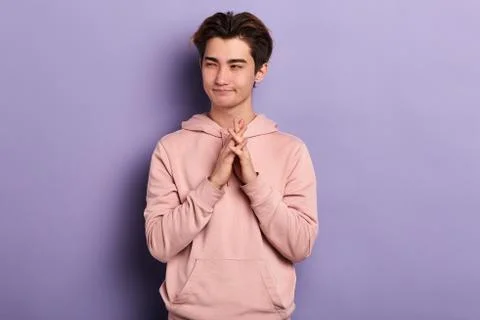 Cunning man makes grimace, keeps palms together Stock Photos
