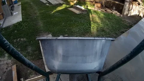 Cunstruction worker carrying empty cement cart POV Stock Footage 90892400