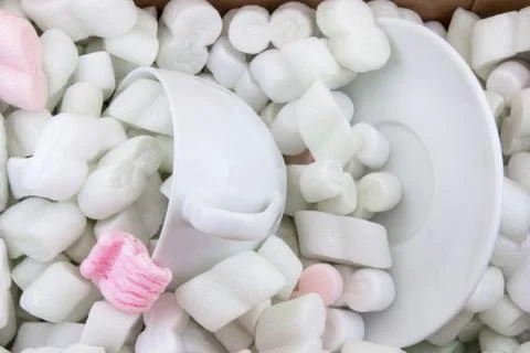 Cup and saucer packed in peanuts for shipping. Stock Photos