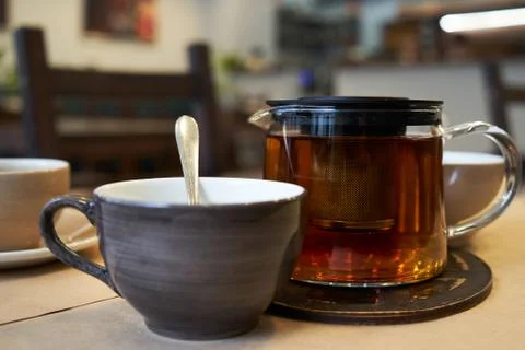 Cup and teapot on a table in a cafe. Stock Photos
