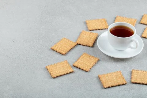 A cup of aroma tea with crackers on a gray background Stock Photos
