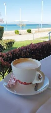 A cup of aromatic coffee on a table in a cafe by the sea Stock Photos