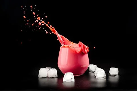 A cup of beet latte on a dark background with ice. Healthy eating alternative to Stock Photos