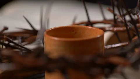 Cup being filled with wine with Crown of Thorns and old Bible in the back Stock Footage 128556234