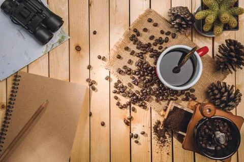 Cup black coffee and coffee beans, Coffee grinder, map, binoculars on the t.. Stock Photos