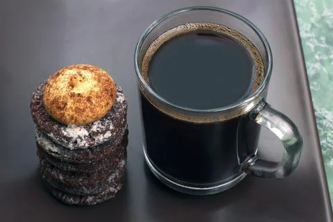 Cup of black coffee with biscuits on a dark plate Stock Photos