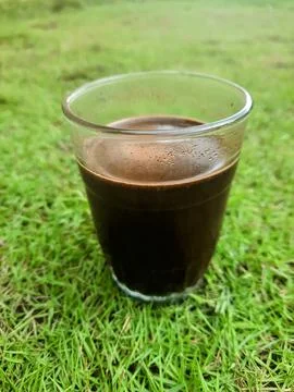 A cup of black coffee on the grass Stock Photos