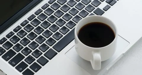 Cup of black coffee on the laptop computer touchpad. Stock Footage 278017552