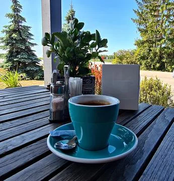 Cup of black coffee on makeshift table in the yard of village house Stock Photos