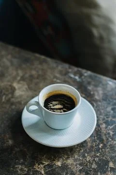 Cup of black coffee on a marble table in a cafe. Stock Photos