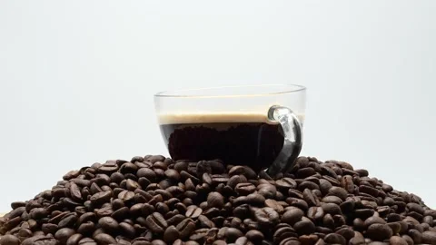 Cup Black Coffee On Roasted Coffee Beans Against White Background Rotated. 库存影片 194891113