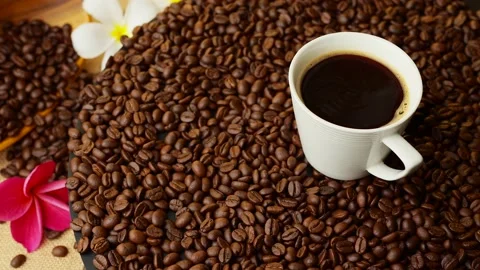 Cup Black Coffee Rotated On Roasted Coffee Beans. Stockbeeldmateriaal 197014231