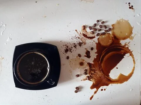 A cup with black coffee on the table and traces of spilled coffee Stock Photos