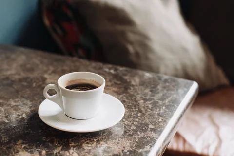 Cup of black coffee on a table in a cafe. Selective focus. Stock Photos