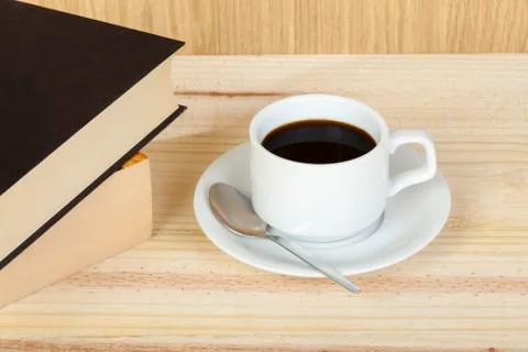 Cup of black coffee on table with reading books 스톡 사진
