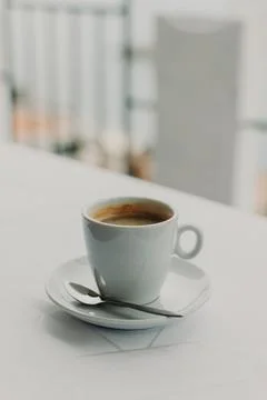 Cup of black coffee on a white table in a street cafe. Selective focus. Pla.. Фото