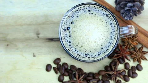 Cup with black, hot coffee standing on brown, roasted beans on sacking Stock Footage 82707906