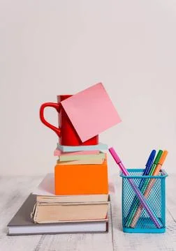 Cup blank colored sticky note stacked note pads books square box pens meta... Stock Photos