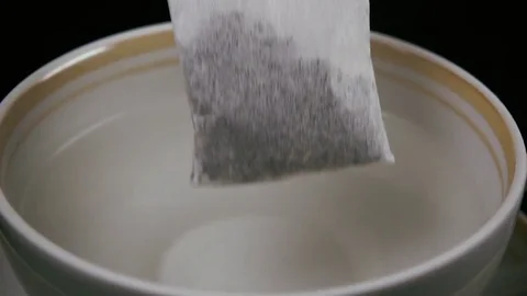In a cup of boiling water throw a bag of tea. Slow motion Video stock 75811510