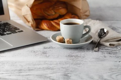 Cup of brew coffee on table in office with laptop Stock-Fotos