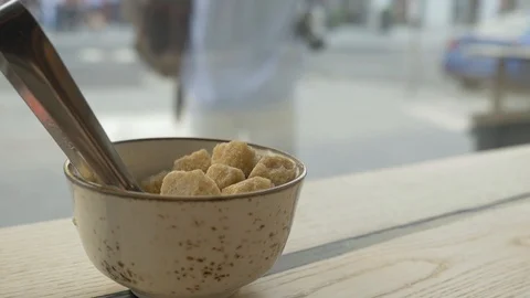 A cup of brown sugar is on the table in the cafe, opposite the large window. Video stock 94917170