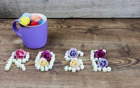 Cup of button roses with the text rose formed with marshmallows. Stock Photos